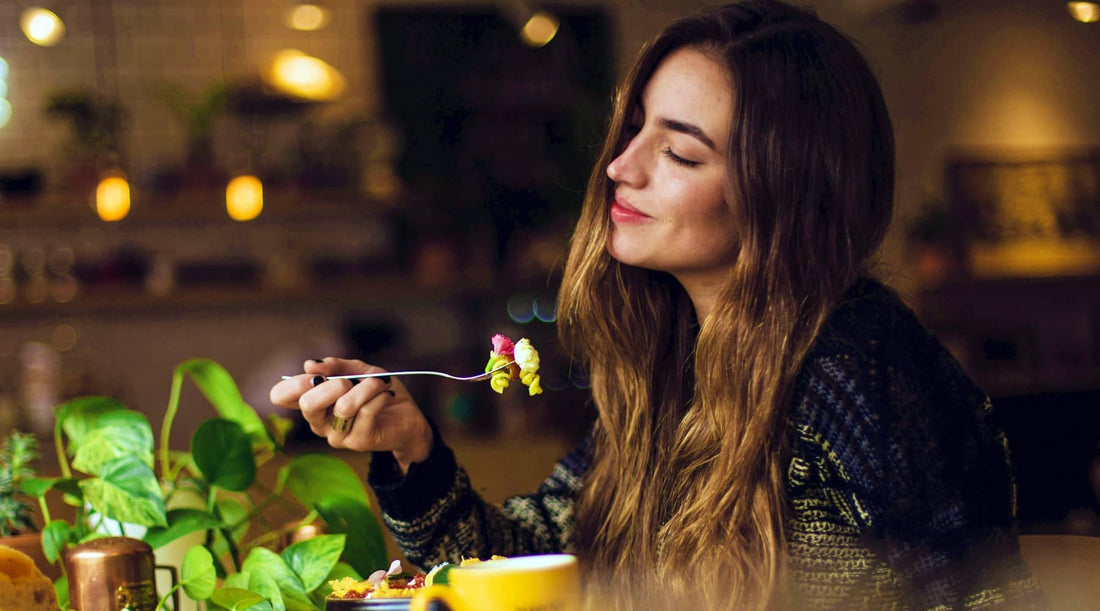 A woman sensibly eating a healthy meal and feeling satisfied after blocking out food noise.