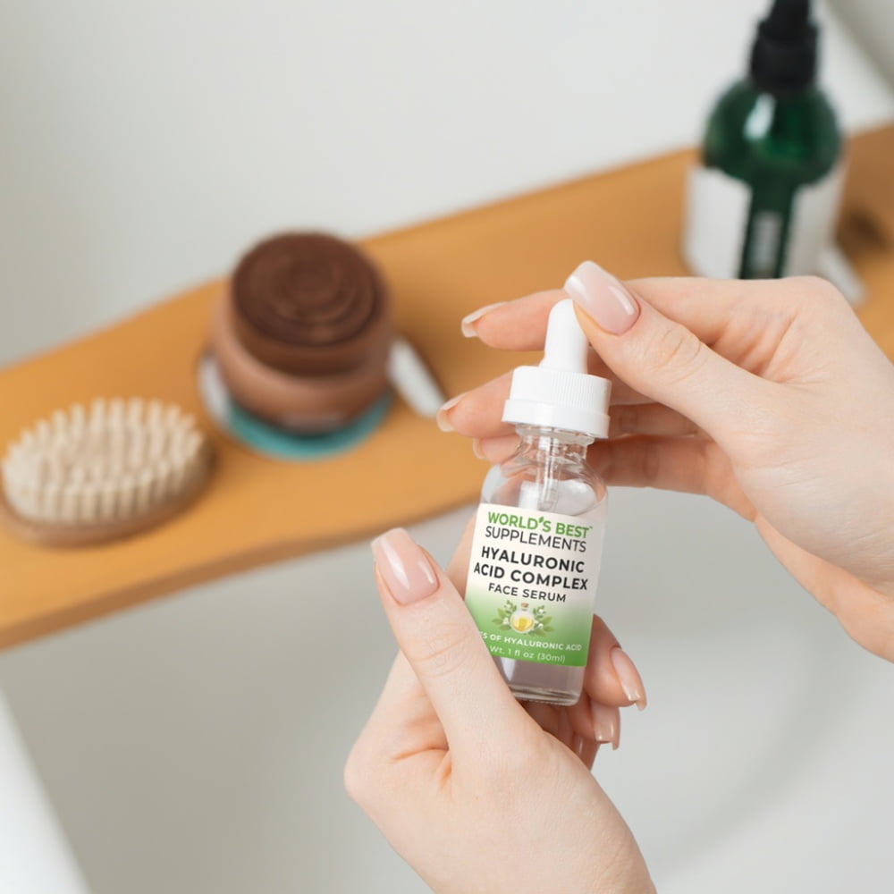 A woman holding a bottle of Hyaluronic Acid Face Serum from World's Best Supplements.