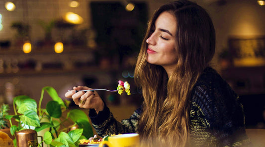 A woman sensibly eating a healthy meal and feeling satisfied after blocking out food noise.