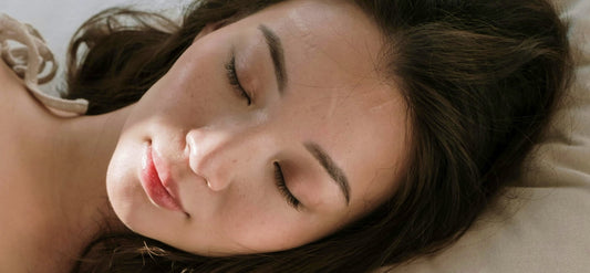 Closeup of a woman sleeping well and stress free in a comfortable bed after taking Magnesium Glycinate.