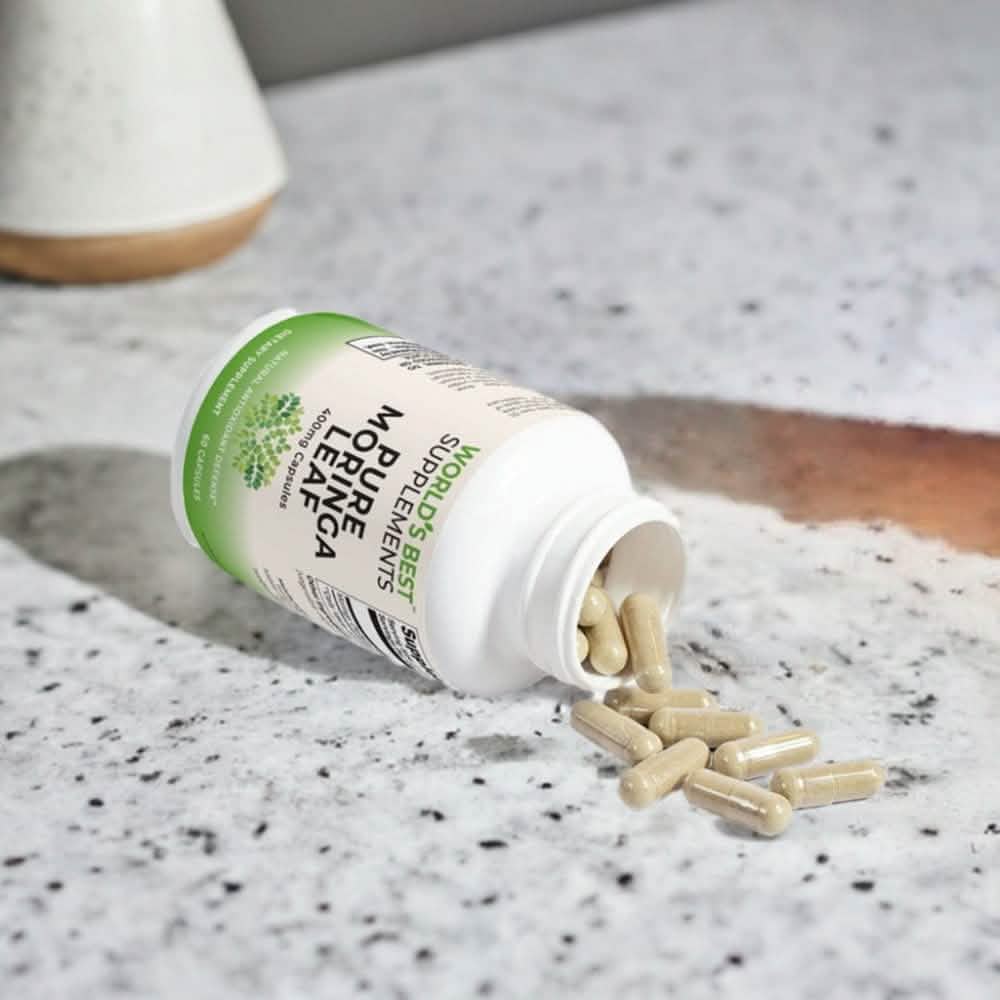 A bottle of 100% Natural Moringa 400mg Capsules open on a counter to show the pills from World's Best Supplements.